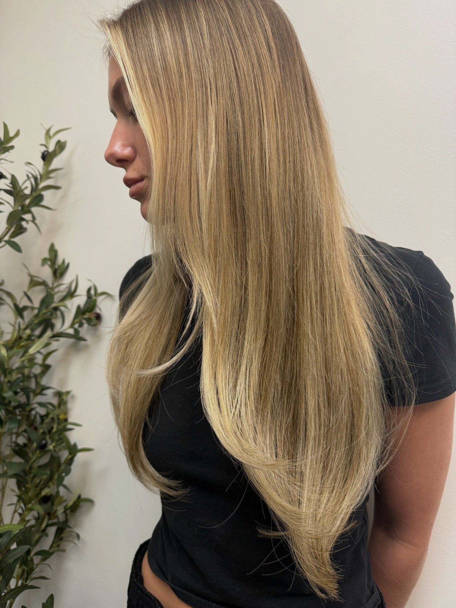 After: the same client with long, layered lived-in blonde after custom color and a K-tip install