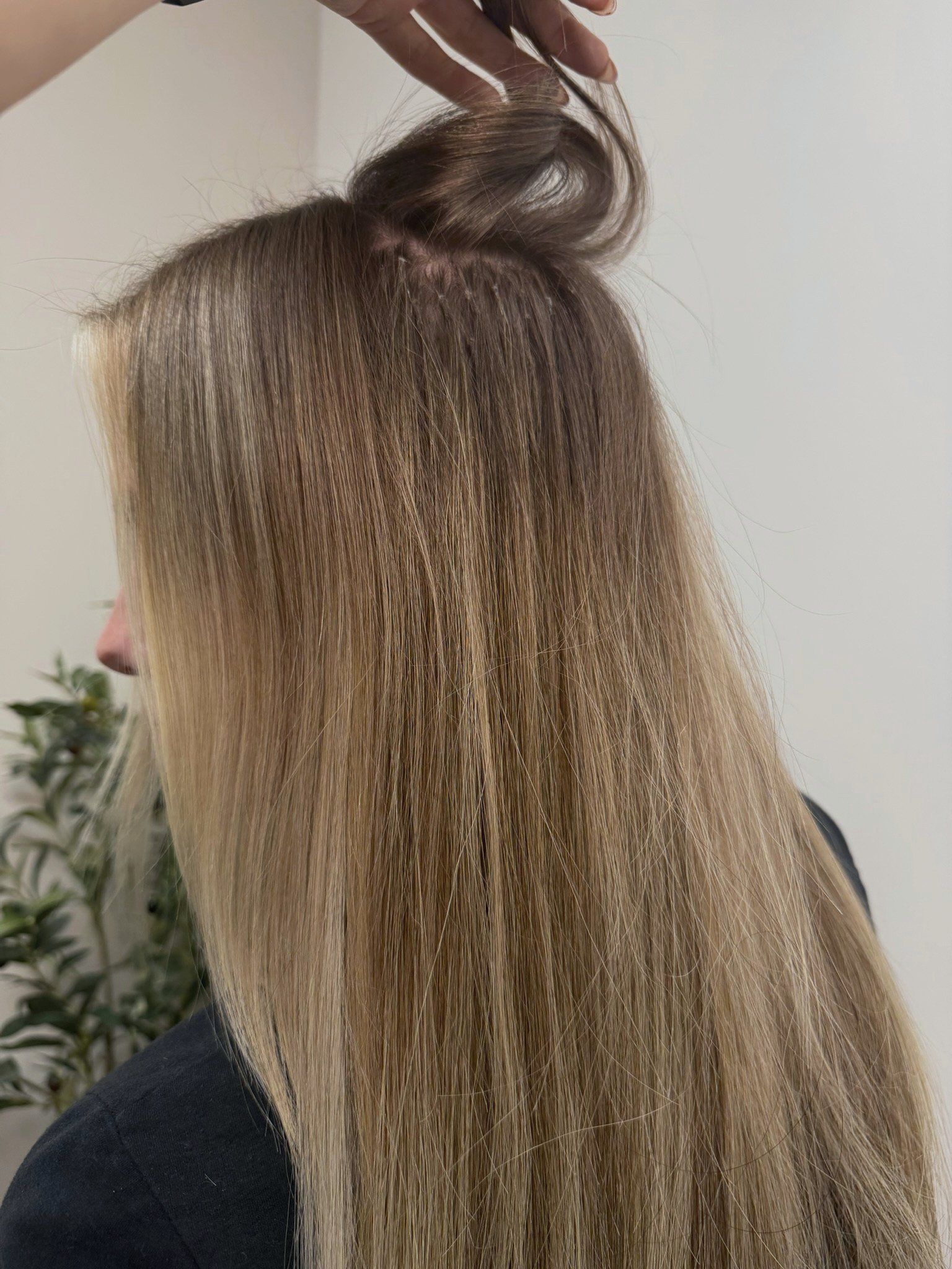 Keratin bonds peeking under lived-in blonde hair