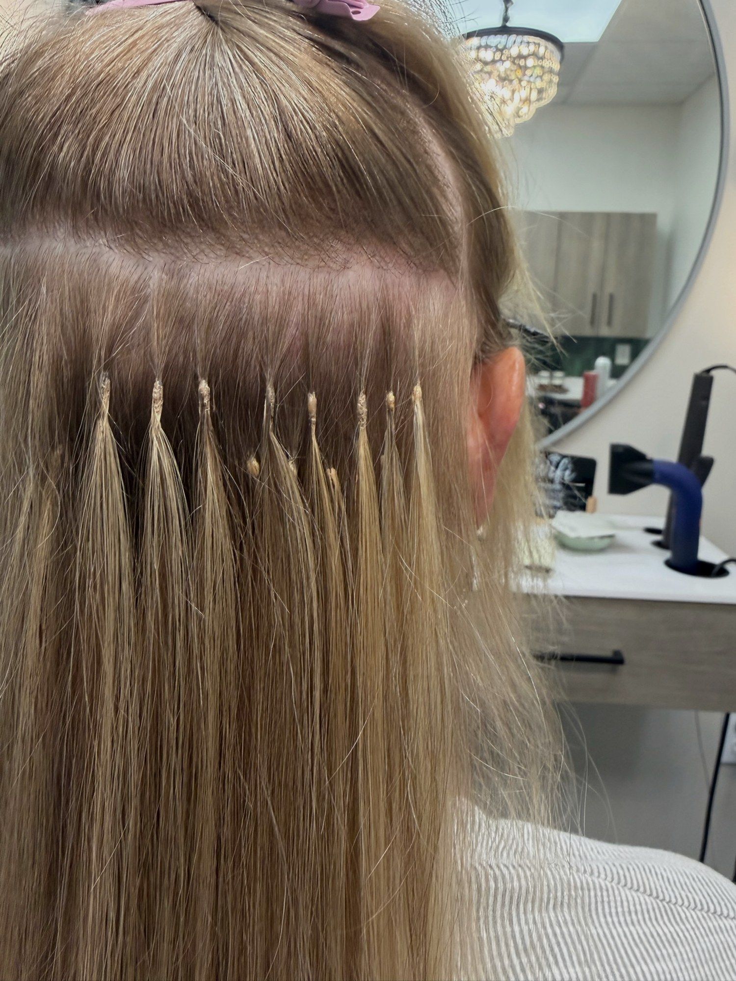 Rows of keratin bond extensions placed along the back of a client’s head