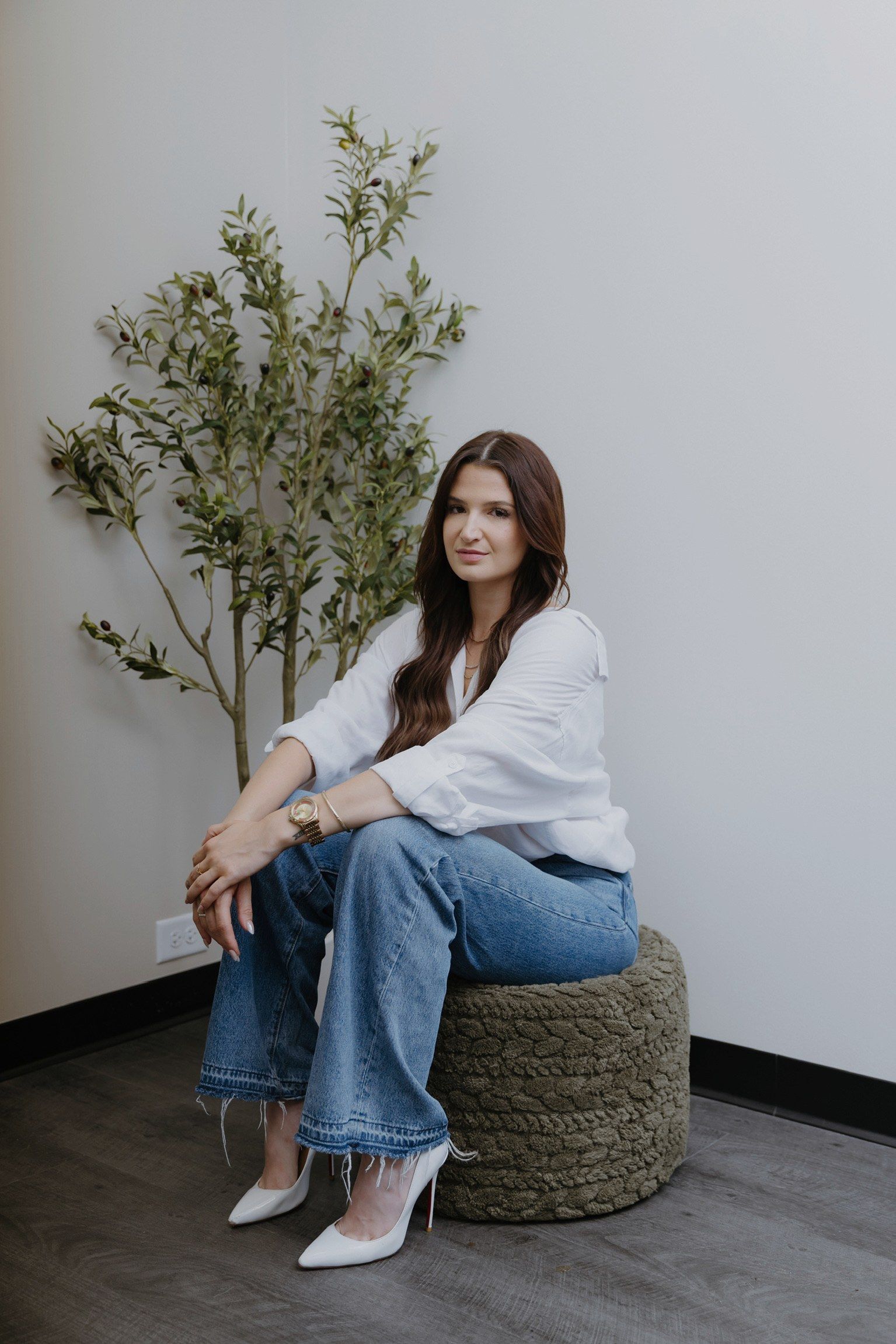 Megan Hudgin in her studio, seated beside the olive tree