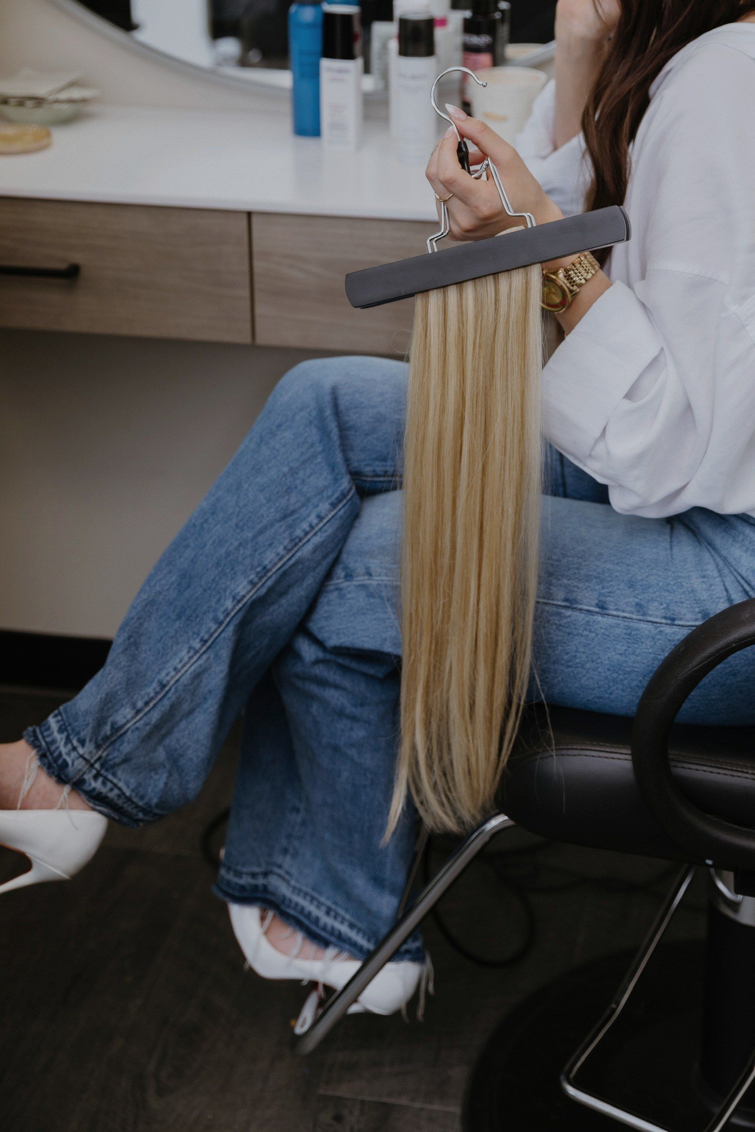 Megan holding a single beaded weft of blonde extension hair