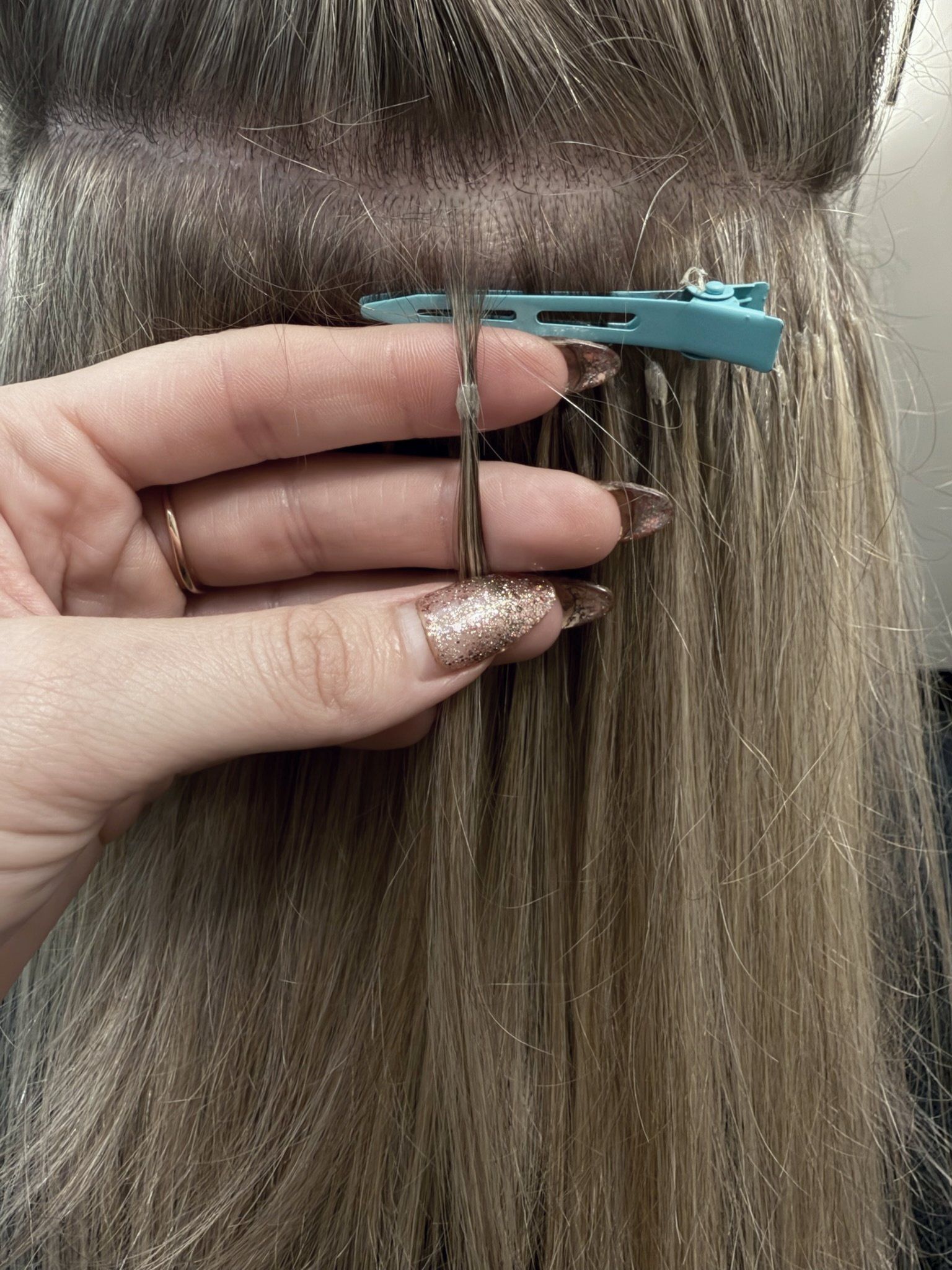 A keratin bond held at the root above a sectioning clip