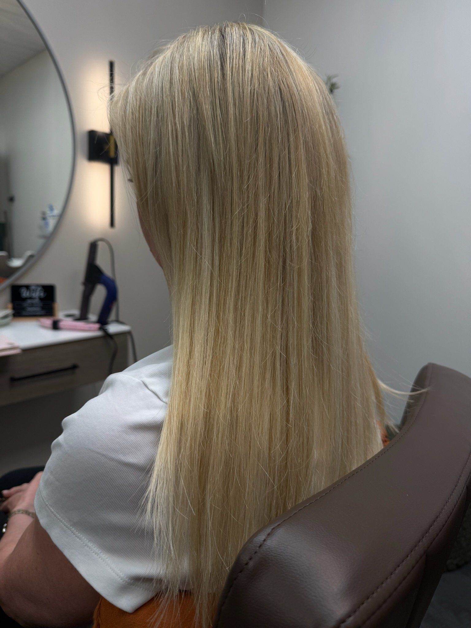 A finished K-tip install on long blonde hair, from the back