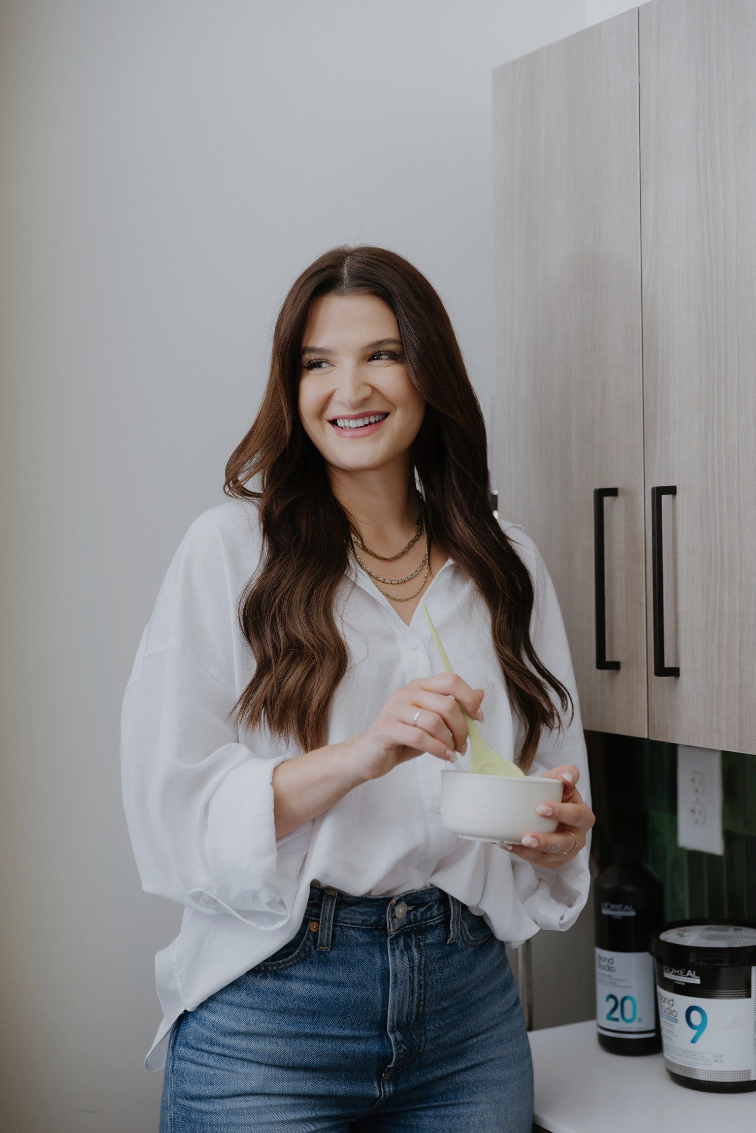 Megan smiling while mixing color in a bowl at her studio