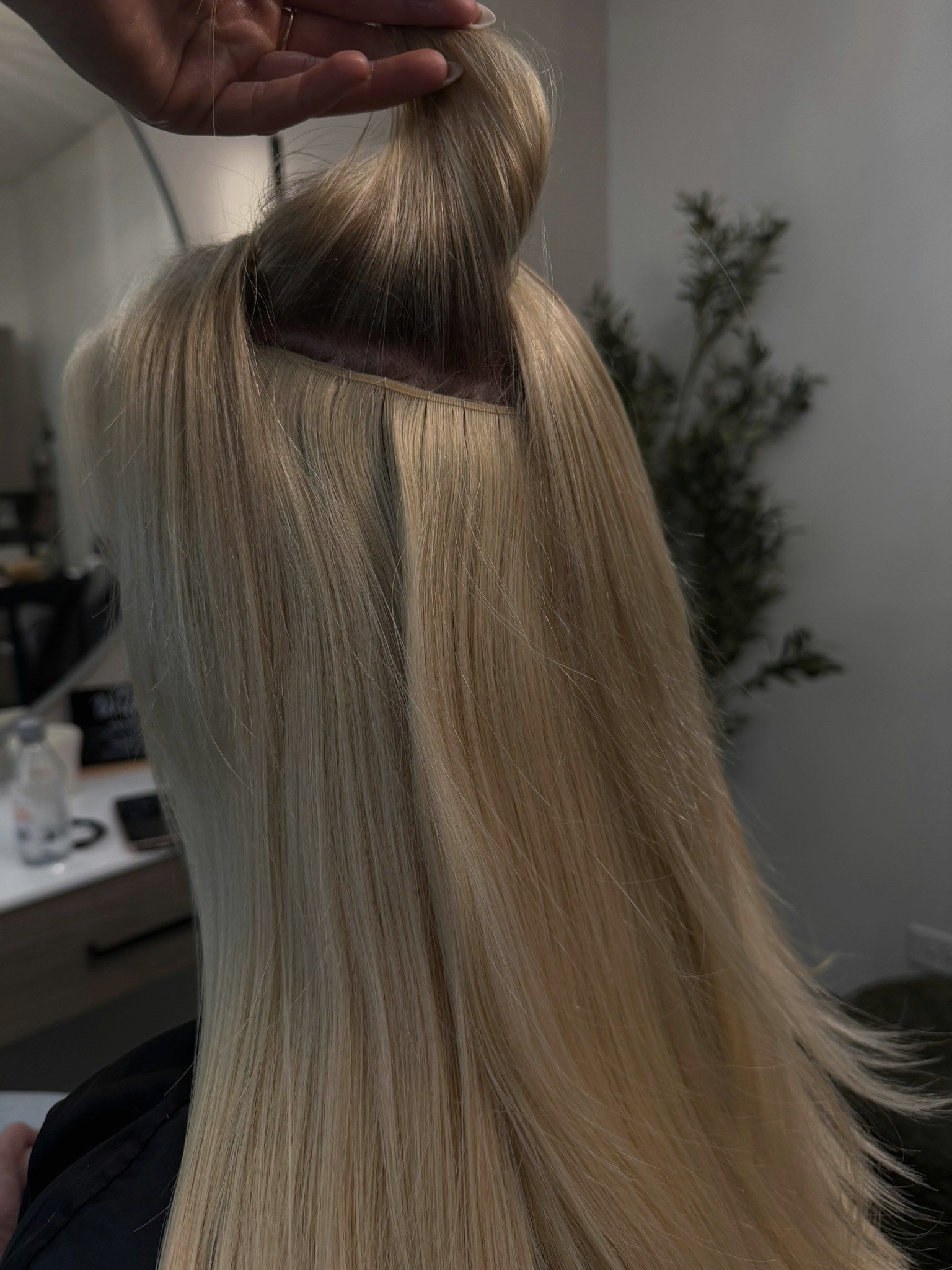 A row of volume wefts under lifted hair on a bob